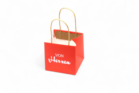 Kleine rote Geschenktüte mit dem Aufdruck "Von Herzen".